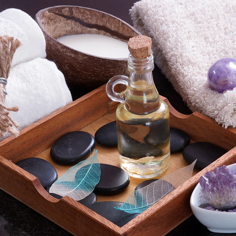 Hot stones, oil and towels on a spa tray